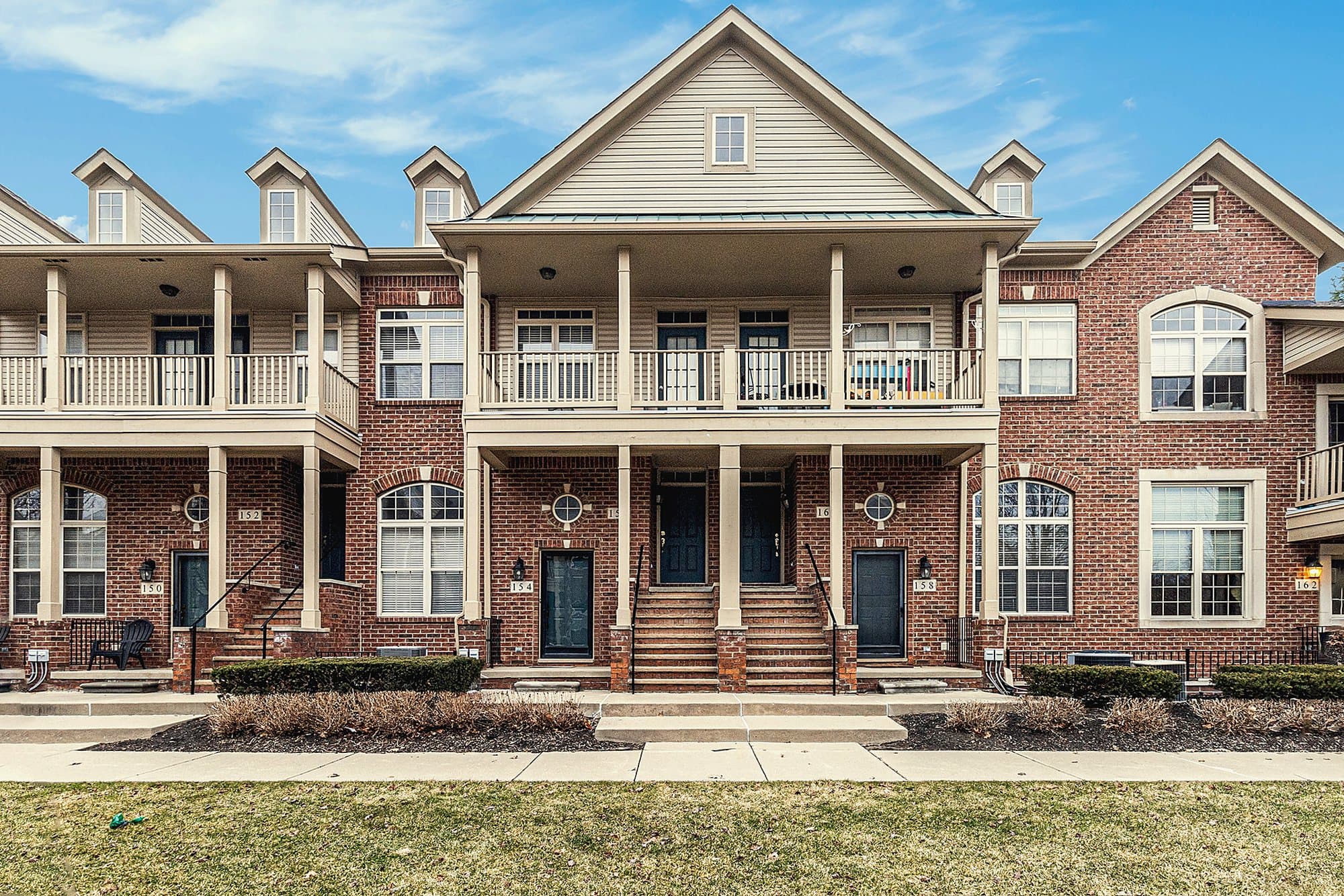 Row of brick townhomes with covered porches